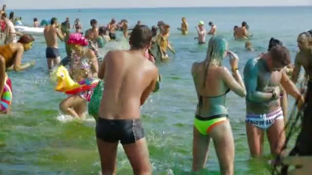 Krim, Oekraïne, 06 augustus 2013, deelnemers van kazantip 2013 probeert weg te wassen de verf in de zee . — Stockvideo