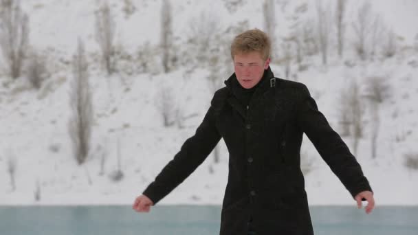 Jovem esperando alguém no parque de inverno — Vídeo de Stock