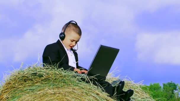 Giovane uomo d'affari. Bambino vestito con una tuta che lavora con il computer portatile . — Video Stock