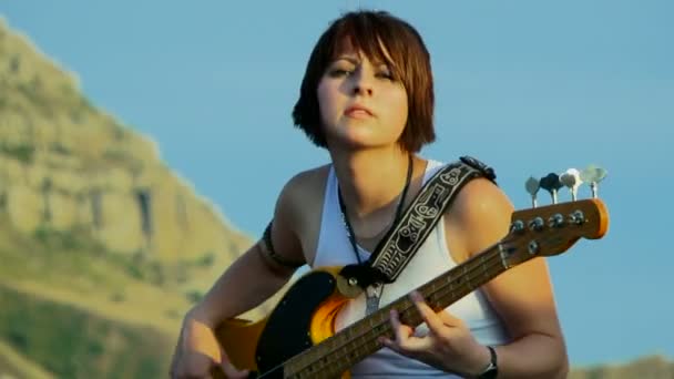 Mujer joven tocando la guitarra al aire libre. Joven guitarrista . — Vídeos de Stock