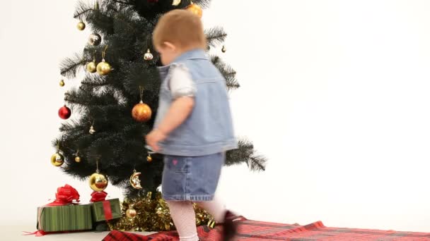 Niño encontrando regalos bajo el árbol de Navidad. Regalos bajo el árbol de Navidad . — Vídeos de Stock