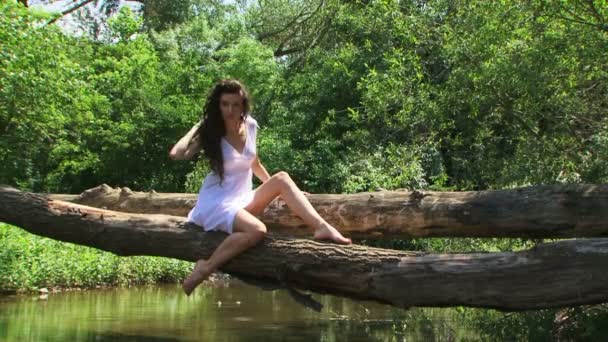 Gekrulde model poseren op een riverside. — Stockvideo