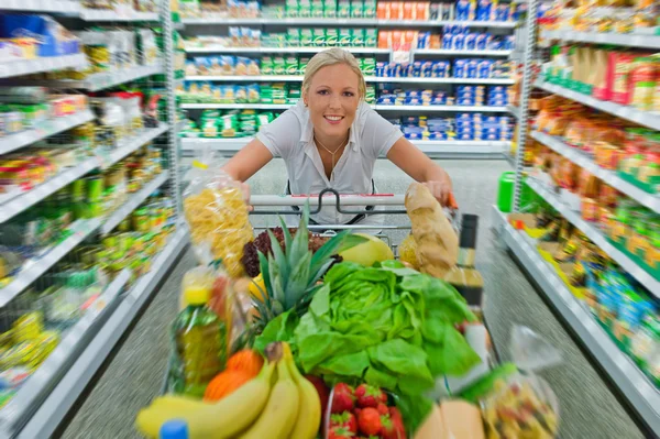 Nő a bevásárlókocsi a szupermarketben — Stock Fotó