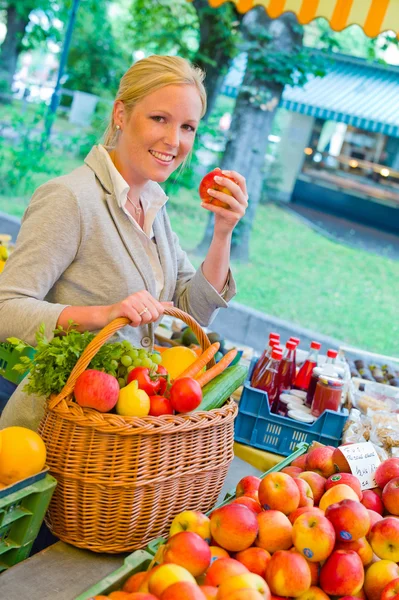 Vrouw op de markt voor fruit met mandje — Stockfoto
