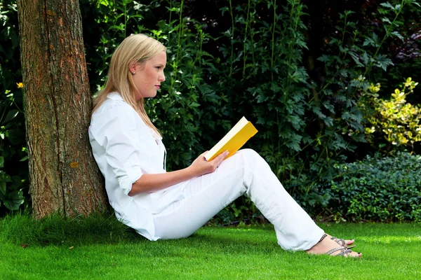 Kvinna läsa bok i parken — Stockfoto