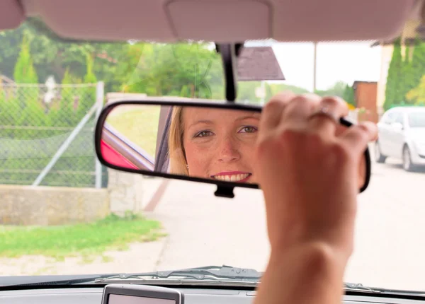Wanita meluruskan spion di mobil. — Stok Foto