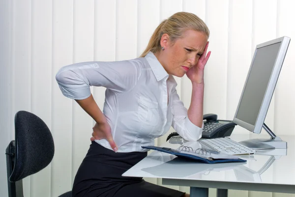 Frauen im Büro mit Rückenschmerzen — Stockfoto