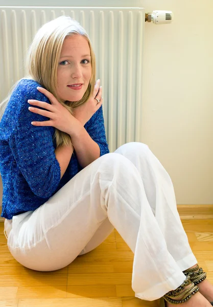 Femme assise devant un radiateur — Photo