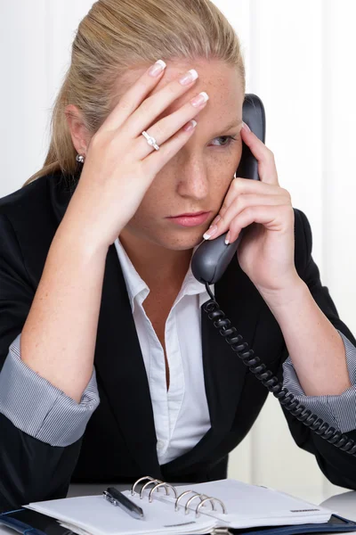 Frustrated woman with phone in office — Stock Photo, Image