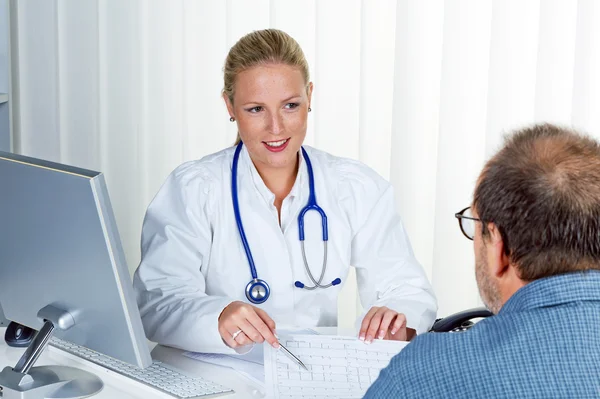 Женщина-врач со стетоскопом разговаривает с пациентами — стоковое фото