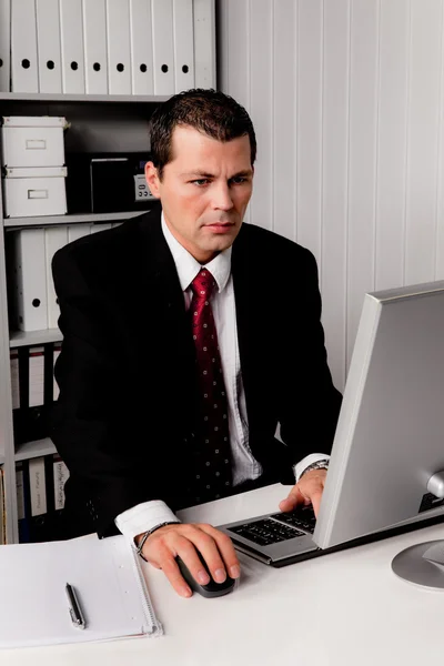 Бизнесмен в офисе с компьютером — стоковое фото