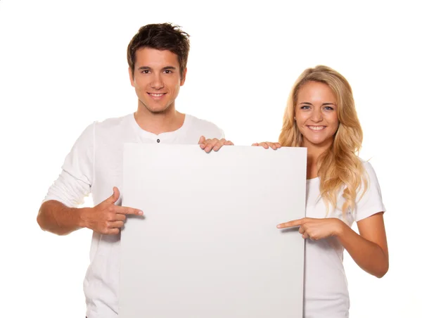 Couple with empty poster to advertise the opening — Stock Photo, Image