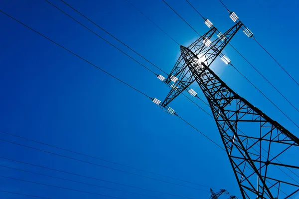 Pilón eléctrico con sol y cielo — Foto de Stock