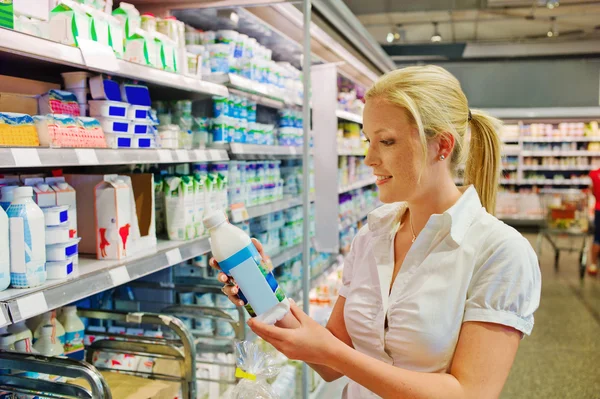 Woman buying milk at the grocery store Stock Picture