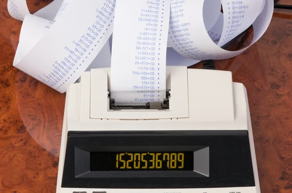 Calculadora de escritorio con tiras para los costos de computación, gastos, re — Foto de Stock