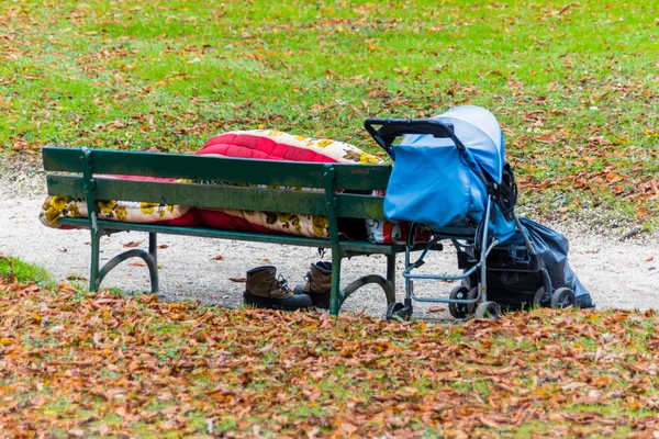 Hajléktalan férfi egy padon — Stock Fotó