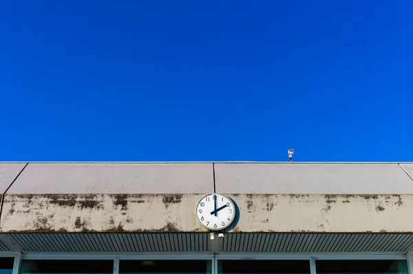 Um relógio na frente do céu azul — Fotografia de Stock