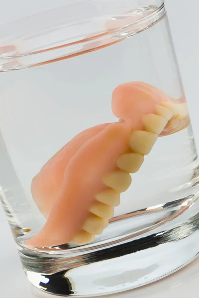 Dentures in a water glass — Stock Photo, Image