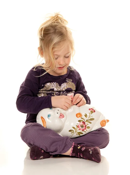 Child with piggy bank with savings of greenbacks — Stock Photo, Image