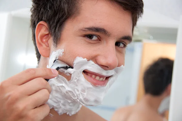 Man shaves with a razor blade and rasierschau — Stock Photo, Image