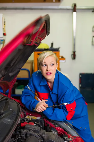 Woman as a mechanic in car workshop — Stock Photo, Image
