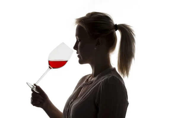Mulher com vinho tinto em um copo de vinho — Fotografia de Stock