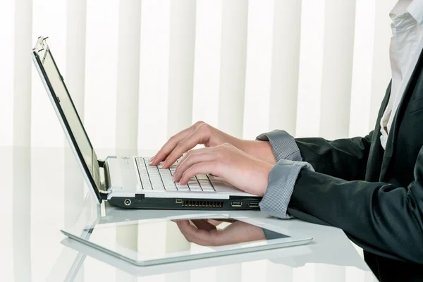 Woman in office with laptop computer com — Stock Photo, Image