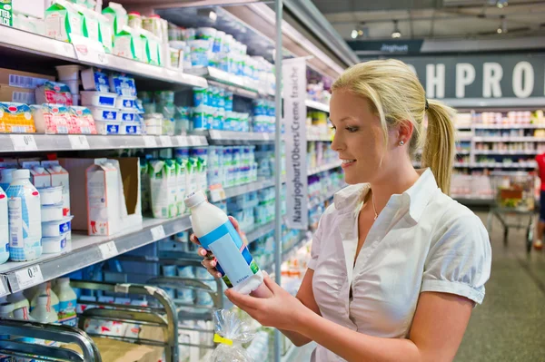 Woman buying milk at the grocery store Royalty Free Stock Images