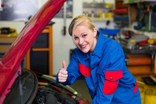 自動車修理工場で整備士として働く女性は — ストック写真