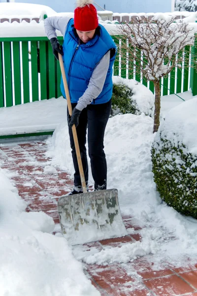 Лопати сніг взимку — стокове фото