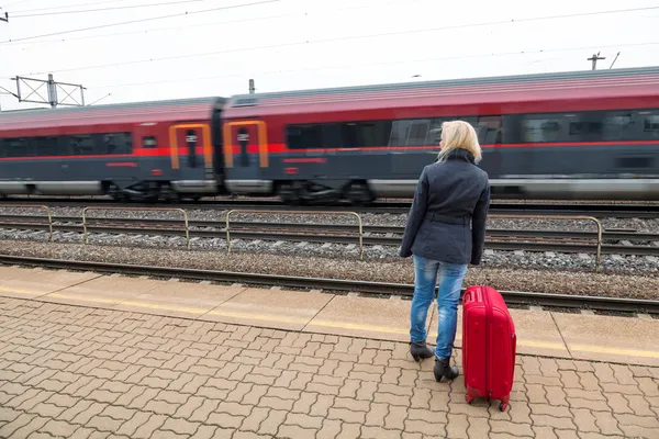 Mulher à espera de estação de trem em sua — Fotografia de Stock