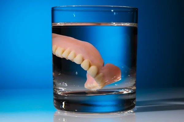 Denture in water glass — Stock Photo, Image