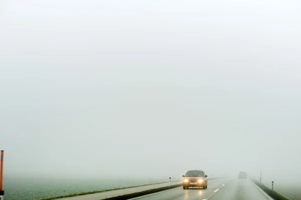 Dimma på en väg med bilar — Stockfoto