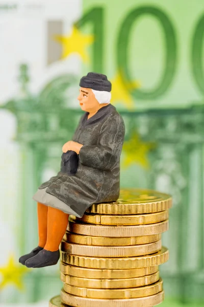 Pensioner sitting on cash pile — Stock Photo, Image