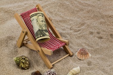 Beach chair with piggy bank and dollars clipart