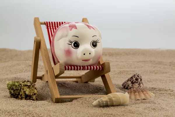 Ligstoel met piggy bank — Stockfoto