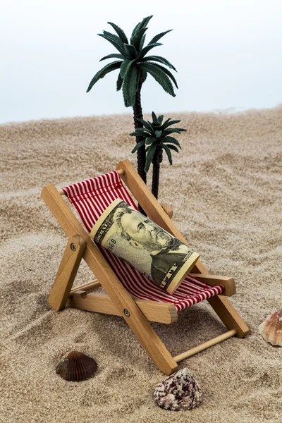 Strandstoel met piggy bank en dollars — Stockfoto