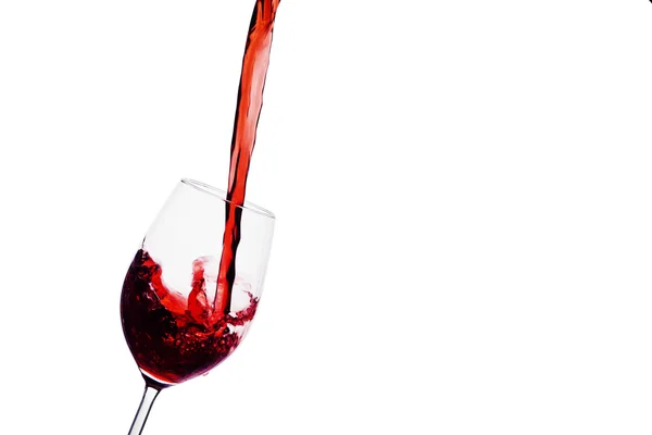 Rött vin hälls i ett vinglas — Stockfoto