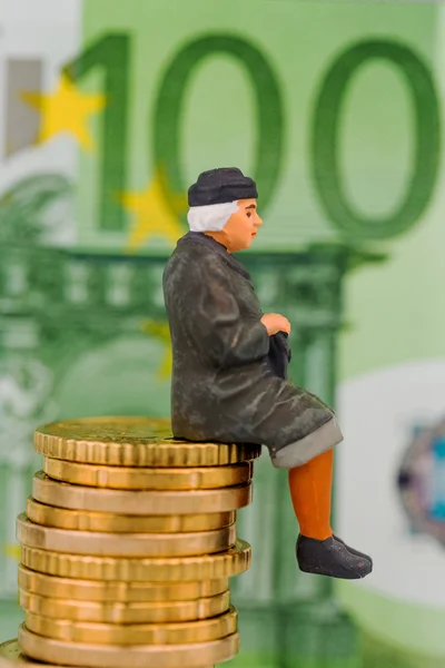 Pensioner sitting on cash pile — Stock Photo, Image