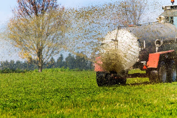 Traktor termékenyít a trágya mező — Stock Fotó