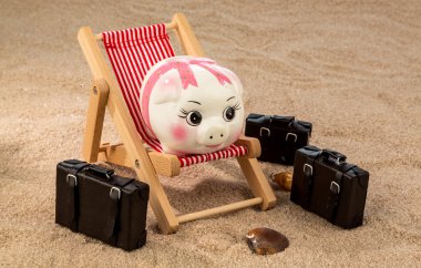 Piggy bank in a deck chair clipart