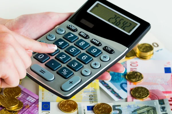 Hand mit Taschenrechner und Geld — Stockfoto