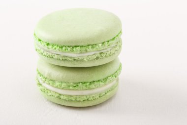 beyaz zemin üzerine yeşil acıbadem kurabiyesi