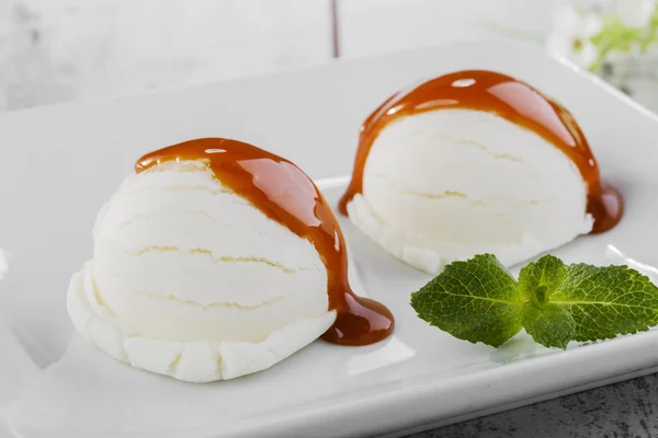 Bola de helado blanco en un plato con caramelo —  Fotos de Stock