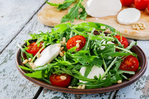 Arugula salad with mozzarella cheese and cherry tomatoes — Stock Photo, Image