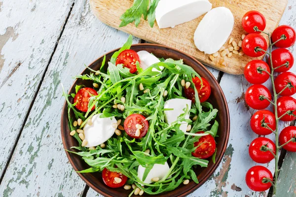 Arugula salad with mozzarella cheese and cherry tomatoes — Stock Photo, Image