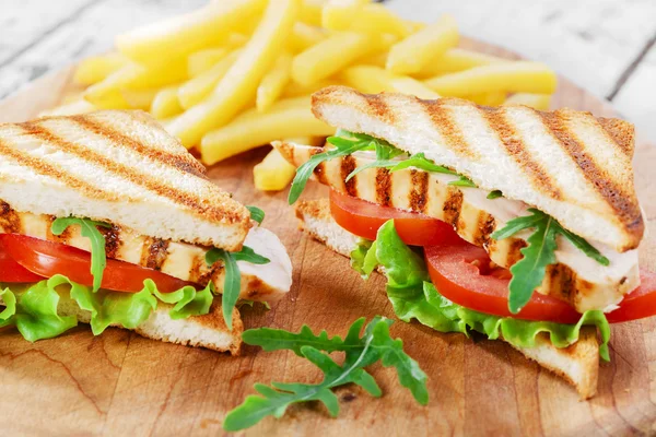 Sanduíche com frango grelhado e tomate batatas fritas — Fotografia de Stock