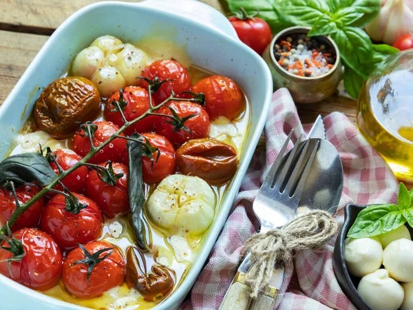 烤蔬菜番茄 莫扎拉奶酪 大蒜在烤箱陶瓷盘 免版税图库图片