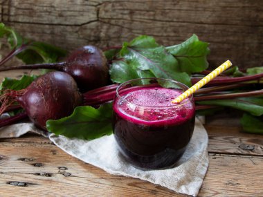 Taze meyve suyu sıkılmış pancar suyu, tahta bir yüzey üzerinde bir bardakta.