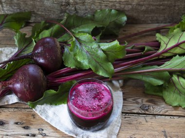 Taze meyve suyu sıkılmış pancar suyu, tahta bir yüzey üzerinde bir bardakta.